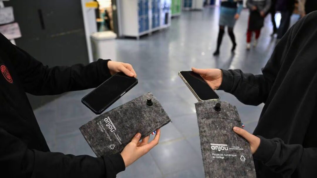 Deux collégiens rangent leurs smartphones dans la pochette Ma pause numérique
